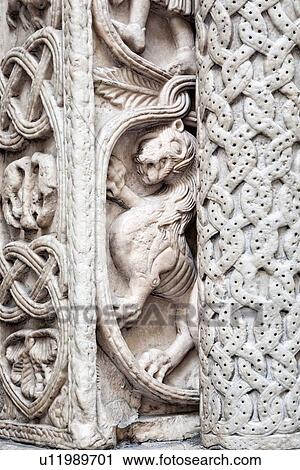 Stock Image - Genoa Centro Storico: Duomo of San Lorenzo, detail of marble carved column of facade, with lion rampant and garlands, Genova, Italy. Fotosearch