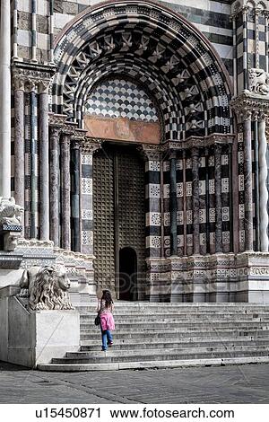 Genoa Centro Storico: Duomo of San Lorenzo, facade detail with ornate marble columned entranceway, carved marble lion frontal view, with woman standing, Genova, Italy View Large Photo Image Stock Image - Genoa Centro Storico: Duomo of San Lorenzo, facade detail with ornate marble columned entranceway, carved marble lion frontal view, with woman standing, Genova, Italy. Fotosearch