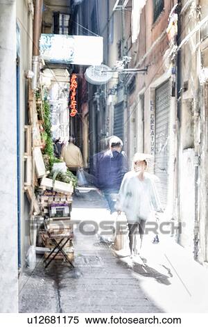 Genoa Centro Storico: narrow alley with fruit and vegetable stand in bright light, withpeople walking, motion blur abstract effect, Genova, Italy View Large Photo Image Stock Photography - Genoa Centro Storico: narrow alley with fruit and vegetable stand in bright light, withpeople walking, motion blur abstract effect, Genova, Italy. Fotosearch