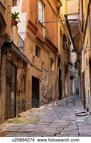 Genoa Centro Storico: narrow cobbled alleyway with medieval stone facade visible under peeling paint and graffitti covered stucco, Genova, Italy View Large Photo Image Picture - Genoa Centro Storico: narrow cobbled alleyway with medieval stone facade visible under peeling paint and graffitti covered stucco, Genova, Italy. Fotosearch