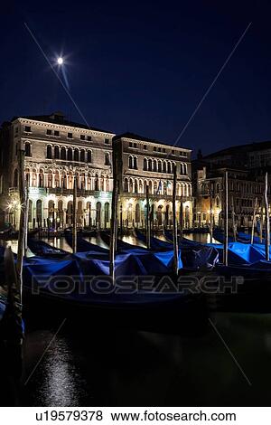Gondolas rocking on a tranquil Grand canal at nightime in the moonlight with view of ornate Palazzi beyond, Venice Italy View Large Photo Image Stock Photo - Gondolas rocking on a tranquil Grand canal at nightime in the moonlight with view of ornate Palazzi beyond, Venice Italy. Fotosearch