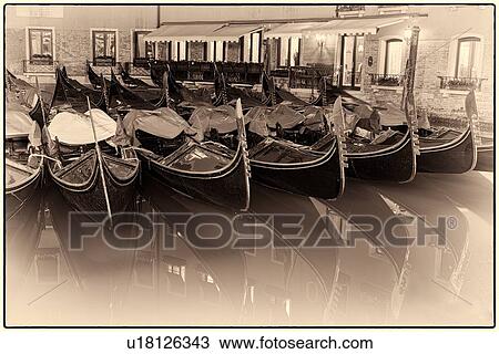 Gondoliers moored at night: detail of pattern of boats alongside each other in Orseolo Basin, with reflections, monochrome image, near San Marco, Venice, Italy View Large Photo Image Stock Image - Gondoliers moored at night: detail of pattern of boats alongside each other in Orseolo Basin, with reflections, monochrome image, near San Marco, Venice, Italy. Fotosearch