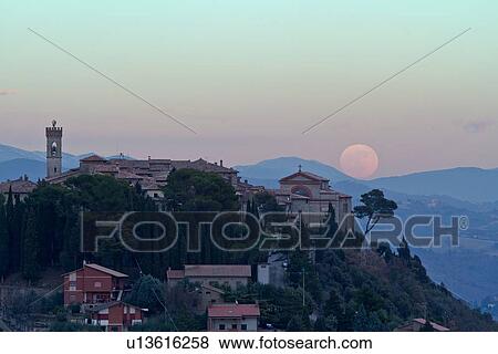 Hilltop medieval town of MonteCastello di Vibio with full moon rising above church and campanile, hills beyond, Umbria, Italy View Large Photo Image Stock Photo - Hilltop medieval town of MonteCastello di Vibio with full moon rising above church and campanile, hills beyond, Umbria, Italy. Fotosearch