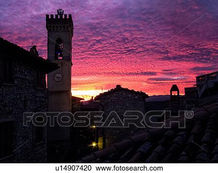 Medieval hilltop town of MonteCastello di Vibio: piazza at dusk, with close up of campanile and old stone buildings silhouetted against amazing ornage purple pink sky, Umbria, Italy View Large Photo Image Stock Image - Medieval hilltop town of MonteCastello di Vibio: piazza at dusk, with close up of campanile and old stone buildings silhouetted against amazing ornage purple pink sky, Umbria, Italy. Fotosearch