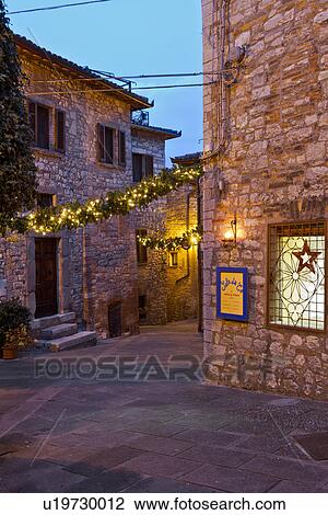Medieval hilltop town of MonteCastello di Vibio: street at dusk, with night lights, and Christmas garlands strung between the old stone houses, Umbria, Italy View Large Photo Image Stock Image - Medieval hilltop town of MonteCastello di Vibio: street at dusk, with night lights, and Christmas garlands strung between the old stone houses, Umbria, Italy. Fotosearch