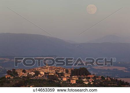 Medieval hilltop town of MonteCastello di Vibio at sunset, as the pale full moon rises over the hills beyond the Tiber valley, Umbria, Italy View Large Photo Image Stock Photo - Medieval hilltop town of MonteCastello di Vibio at sunset, as the pale full moon rises over the hills beyond the Tiber valley, Umbria, Italy. Fotosearch