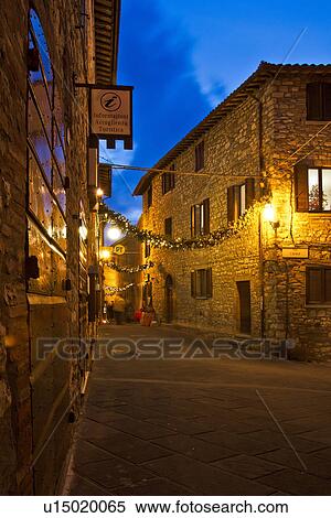 Medieval hilltop town of MonteCastello di Vibio: street at dusk, with night lights, and Christmas garlands strung between the old stone houses, motion blur of people, Umbria, Italy View Large Photo Image Stock Photography - Medieval hilltop town of MonteCastello di Vibio: street at dusk, with night lights, and Christmas garlands strung between the old stone houses, motion blur of people, Umbria, Italy. Fotosearch