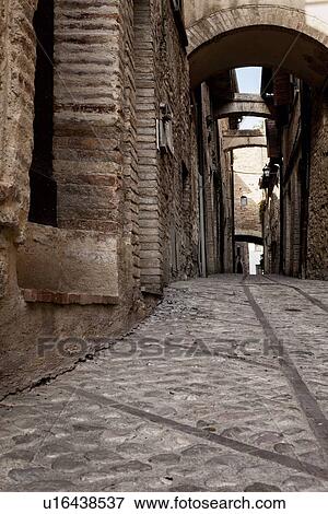 Medieval stone street with cobblestones and linear brick pattern betwee, stone houses with multiple supporting arches across street, Montefalco, Umbria, Italy View Large Photo Image Stock Photo - Medieval stone street with cobblestones and linear brick pattern betwee, stone houses with multiple supporting arches across street, Montefalco, Umbria, Italy. Fotosearch