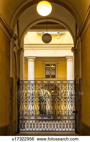 Milan Fashion District: palazzo entranceway with stucco arched ceiling, beautiful wrought iron gate and attractive courtyard beyond, Milan, Italy View Large Photo Image Stock Photograph - Milan Fashion District: palazzo entranceway with stucco arched ceiling, beautiful wrought iron gate and attractive courtyard beyond, Milan, Italy. Fotosearch