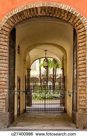 Milan Fashion District: palazzo entranceway with stucco arched ceiling, beautiful wrought iron gate and attractive courtyard beyond, Milan, Italy View Large Photo Image Stock Photograph - Milan Fashion District: palazzo entranceway with stucco arched ceiling, beautiful wrought iron gate and attractive courtyard beyond, Milan, Italy. Fotosearch