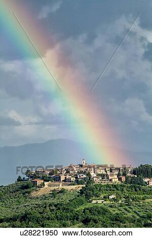 Stock Image - Montecastello di Vibio on stormy spring afternoon with rainbow in blue sky with dramatic clouds, MonteCastello di Vibio, Umbria, Italy. Fotosearch