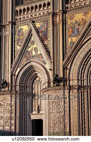 Orvieto Duomo - detail of facade with intricate stone carving, twisted columns with inlaid mosaic panels around doorway, Romanesque-Gothic style, Umbria, Italy View Large Photo Image Stock Image - Orvieto Duomo - detail of facade with intricate stone carving, twisted columns with inlaid mosaic panels around doorway, Romanesque-Gothic style, Umbria, Italy. Fotosearch