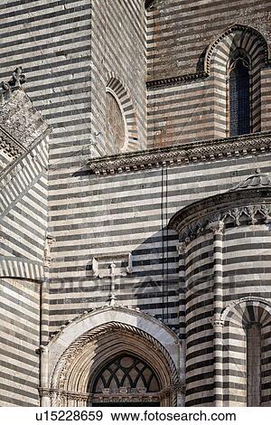 Stock Photo - Orvieto Duomo - detail of side wall with black and white striped stone, curved walls and decorations causing dramatic patterned effect, Romanesque-Gothic style, Umbria, Italy. Fotosearch