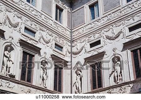 Stock Photo - Palazzo courtyard corner detail with intricate carved statues, garlands, and friezes along wall, Rome, Italy. Fotosearch