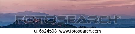 Stock Image - Panorama view of hilltop medieval towns of MonteCastello di Vibio in sunset light, church and campanile, town of Todi, Tiber valley and snowcapped hills beyond, Umbria, Italy. Fotosearch