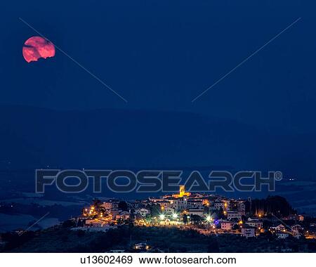 Pink moon partly shaped by cloud over medieval hilltop town of MonteCastello di Vibio with night lights at twilight, and blue sky and hills beyond, Umbria, Italy View Large Photo Image Stock Photo - Pink moon partly shaped by cloud over medieval hilltop town of MonteCastello di Vibio with night lights at twilight, and blue sky and hills beyond, Umbria, Italy. Fotosearch