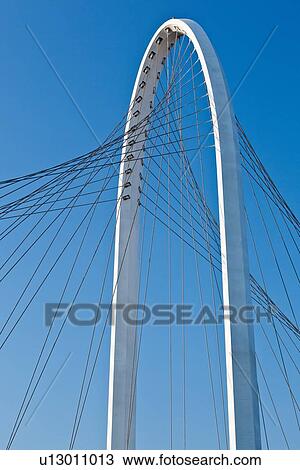 Reggio Emilia bridge by Calatrava, detail showing curved hoop design and suspension wires against blue sky in late afernoon, Emilia Romagna, Italy View Large Photo Image Stock Image - Reggio Emilia bridge by Calatrava, detail showing curved hoop design and suspension wires against blue sky in late afernoon, Emilia Romagna, Italy. Fotosearch