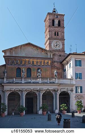 Santa Maria in Trastevere: view of facade with statues on balcony above porticoed entrance, Cavallini mosaic frieze, faded frescoes in architrave, and Romanesque red brick bell tower with clock; lone woman walking across piazza with accordion slung across View Large Photo Image Stock Image - Santa Maria in Trastevere: view of facade with statues on balcony above porticoed entrance, Cavallini mosaic frieze, faded frescoes in architrave, and Romanesque red brick bell tower with clock; lone woman walking across piazza with accordion slung across. Fotosearch