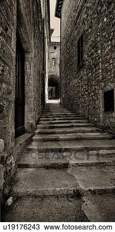 Shallow stone steps in a narrow alley of medieval village houses, leading to arched passageway, Umbria, Italy View Large Photo Image Stock Image - Shallow stone steps in a narrow alley of medieval village houses, leading to arched passageway, Umbria, Italy. Fotosearch