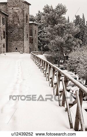Snow-covered fenced pathway around medieval town, stone houses with ancient tower, surrounding trees, winter morning, MonteCastello di Vibio, Umbria, Italy View Large Photo Image Stock Image - Snow-covered fenced pathway around medieval town, stone houses with ancient tower, surrounding trees, winter morning, MonteCastello di Vibio, Umbria, Italy. Fotosearch