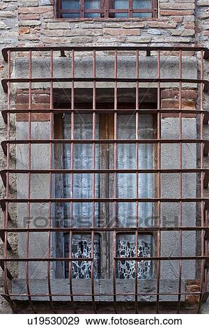 Square glass window with metal grate iin front, rwhite lace curtain hanging, with surrounding stone wall, medieval village, close up view Umbria, Italy View Large Photo Image Stock Photo - Square glass window with metal grate iin front, rwhite lace curtain hanging, with surrounding stone wall, medieval village, close up view Umbria, Italy. Fotosearch