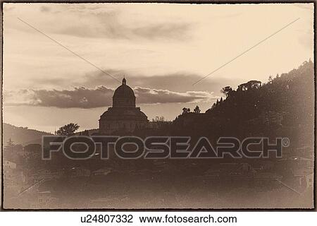Stock Image - Tempio: Santa Maria della Consolazione, Todi at sunset with dramatic sky, stylised monochrome image, Umbria, Italy. Fotosearch