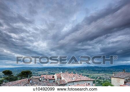Terrace view over red tiled rooftops to Tiber valley and hills beyond, with dramatic storm clouds gathering overhead, Montecastello di Vibio, Umbria, Italy View Large Photo Image Stock Photo - Terrace view over red tiled rooftops to Tiber valley and hills beyond, with dramatic storm clouds gathering overhead, Montecastello di Vibio, Umbria, Italy. Fotosearch