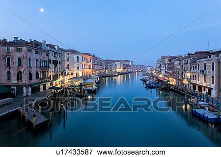 Stock Photo - The Grand canal, empty and silent at dawn with tranquil water and the moon overhead, Venice Italy. Fotosearch