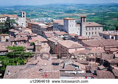 Stock Photo - Todi: aerial view of red tiled rooftops, Palazzo del Populo, Duomo and Tiber valley beyond, on lovely spring morning, Umbria, Italy. Fotosearch