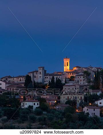 Twilight view of medieval hilltop town of MonteCastello di Vibio. stone houses and belltower, olive groves on slope below, with pink and blue twilight sky, Umbria, Italy View Large Photo Image Picture - Twilight view of medieval hilltop town of MonteCastello di Vibio. stone houses and belltower, olive groves on slope below, with pink and blue twilight sky, Umbria, Italy. Fotosearch