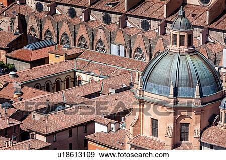 Stock Photo - View from Torre Asinelli of Bologna looking towards the church of Santa Maria della Vita with green dome and Basilica di San Petronio with the red-tiled roofs of the city, Bologna, Italy. Fotosearch
