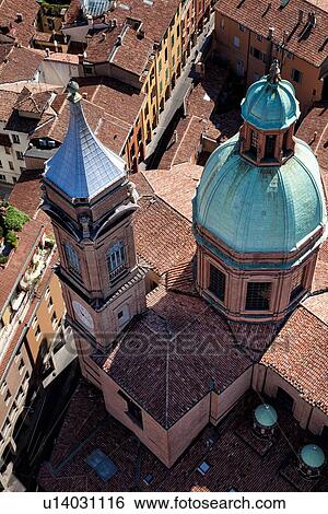 Stock Photograph - View from Torre Asinelli of Bologna looking over church of San Bartolomeo e Gaetano with green dome and bell-tower, to the red-tiled roofs of the city, and Via San Vitale, Bologna, Italy. Fotosearch