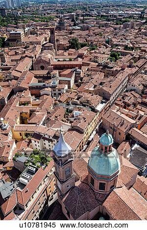Stock Photography - View from Torre Asinelli of Bologna looking over church of San Bartolomeo e Gaetano with green dome and bell-tower, to the red-tiled roofs of the city, Bologna, Italy. Fotosearch