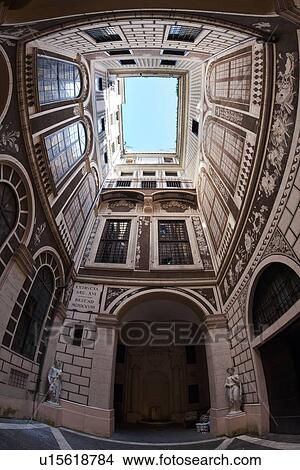 Picture - View looking upwards in courtyard of palazzo, decorated entirely with faux architectural trompe d'oeil designs of French windows, brick, balconies from floor to ceiling, open to blue sky, Rome, Italy. Fotosearch