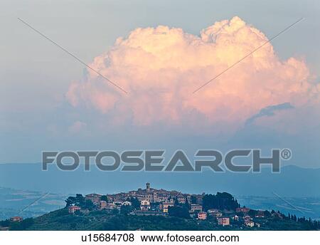 Stock Photo - View of medieval hilltop town of MonteCastello di Vibio, sunset with pink billowing cumulus clouds, and Tiber valley beyond, Umbria, Italy. Fotosearch