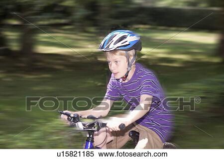 Blurred view of boy riding bicycle View Large Photo Image Stock Photography - Blurred view of boy riding bicycle. Fotosearch