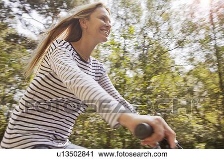 Blurred view of woman riding bicycle View Large Photo Image Stock Image - Blurred view of woman riding bicycle. Fotosearch