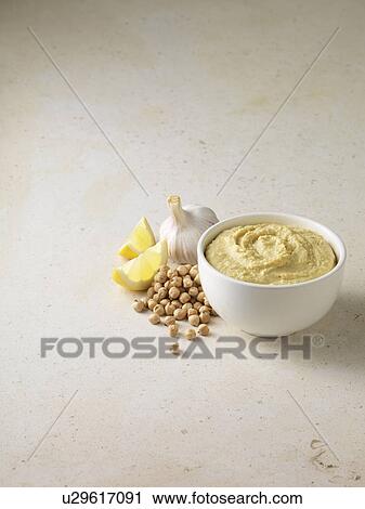 Stock Image - Bowl of houmous with chickpeas. Fotosearch