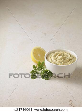 Stock Image - Bowl of houmous with coriander. Fotosearch