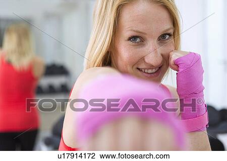 Boxer holding fists up in gym View Large Photo Image Stock Image - Boxer holding fists up in gym. Fotosearch
