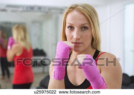 Boxer holding fists up in gym View Large Photo Image Stock Image - Boxer holding fists up in gym. Fotosearch