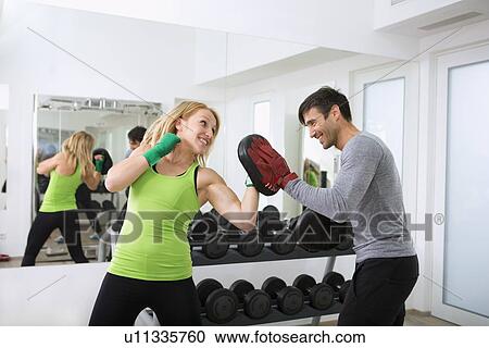 Boxer practicing with trainer in gym View Large Photo Image Stock Image - Boxer practicing with trainer in gym. Fotosearch