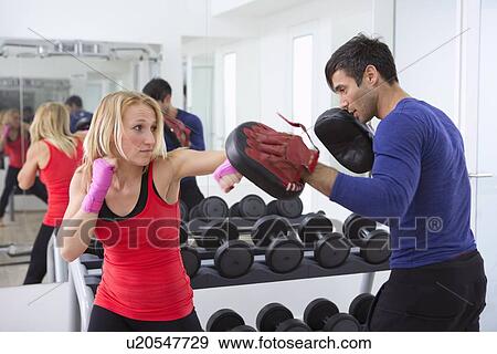 Boxer practicing with trainer in gym View Large Photo Image Stock Photo - Boxer practicing with trainer in gym. Fotosearch