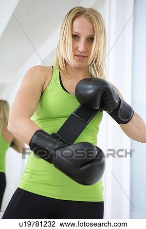 Boxer putting on boxing gloves in gym View Large Photo Image Stock Image - Boxer putting on boxing gloves in gym. Fotosearch