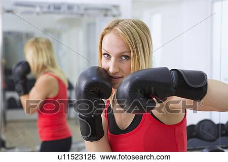 Stock Photograph - Boxer training with gloves in gym. Fotosearch