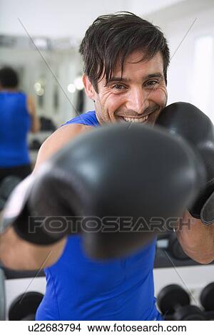 Boxer wearing boxing gloves in gym View Large Photo Image Picture - Boxer wearing boxing gloves in gym. Fotosearch