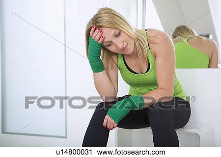 Stock Image - Boxer wiping sweat in gym. Fotosearch