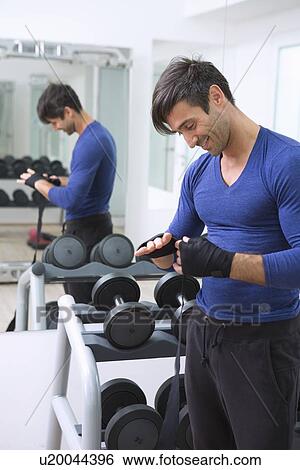 Stock Photograph - Boxer wrapping his hands in gym. Fotosearch