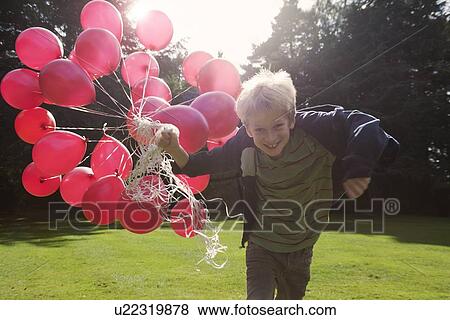 Boy carrying bunch of balloons outdoors View Large Photo Image Stock Photo - Boy carrying bunch of balloons outdoors. Fotosearch