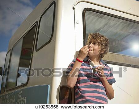 Boy eating ice cream by truck View Large Photo Image Stock Photo - Boy eating ice cream by truck. Fotosearch